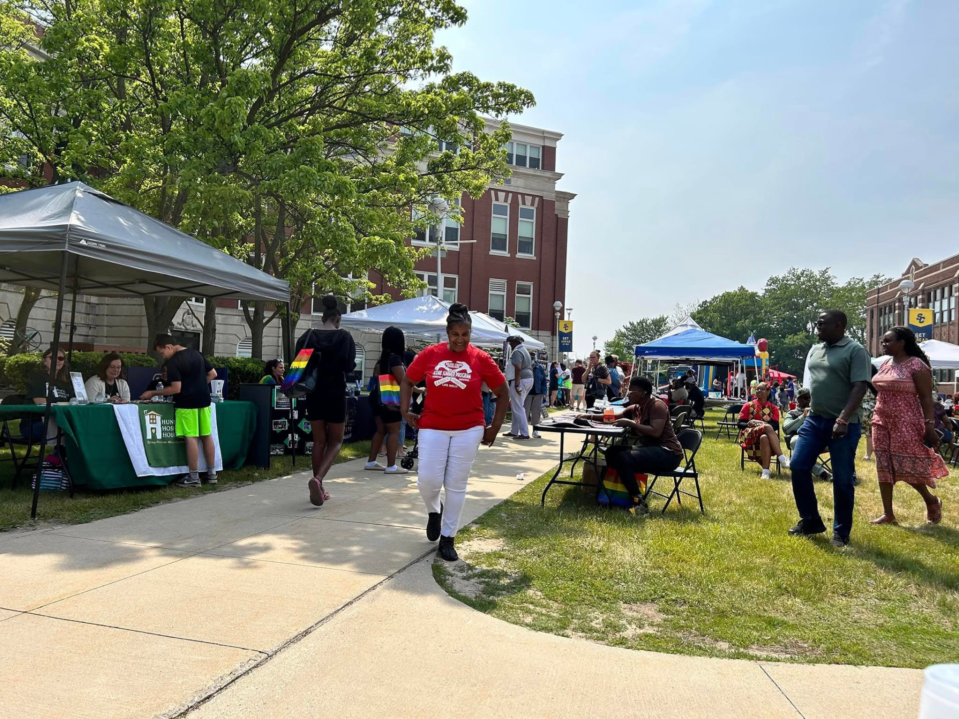 Visitors walking between tents at an outdoor community festival