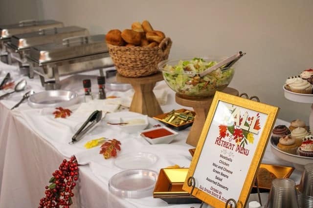 A fall retreat menu displayed beside a buffet spread