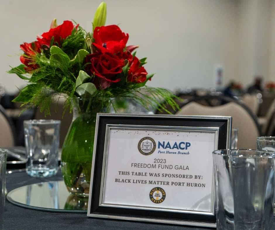 A sponsored table with flowers and a gala table card