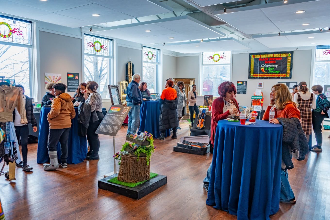 Guests mingling among exhibits at a community reception